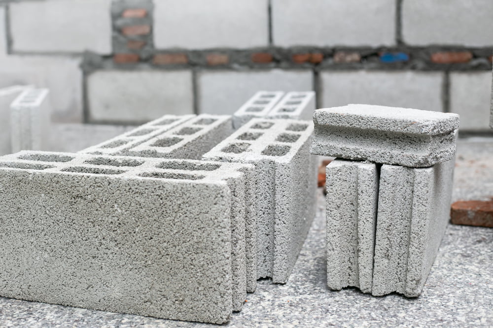 Quais são os tipos de blocos para construção? 4 cement mortar cement powder with trowel put brick construction work