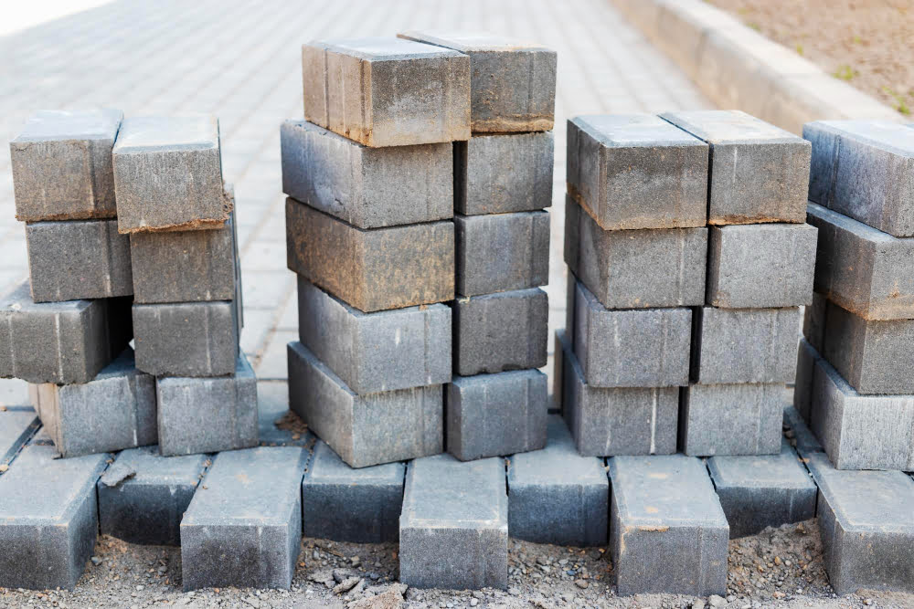 Quais são os tipos de blocos para construção? 3 pavement repairs paving slabs laying prepared surface with tile cubes background laying paving slabs pedestrian zone city paving slabs curbs