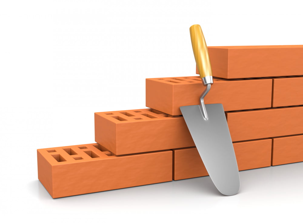 Quais são os tipos de blocos para construção? 2 trowel leaned against wall