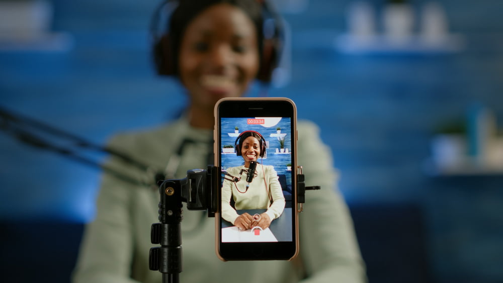 3 dos melhores sites para baixar vídeos do Instagram 2 close up smartphone recording vlog african influencer home studio using smartphone speaking during livestreaming blogger discussing podcast wearing headphones professional microphone